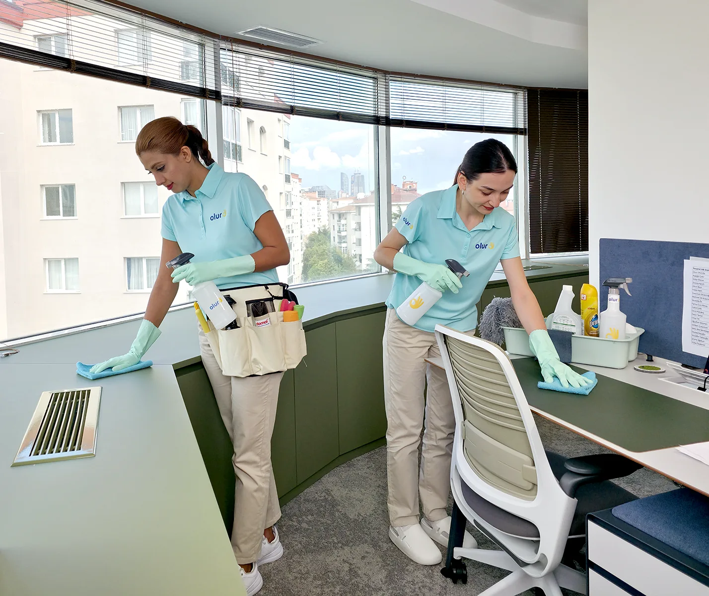 Temizlikçiler, yarım gün ofis temizliği hizmetinde masa silme ve dolap toz alma işlerini yapıyor